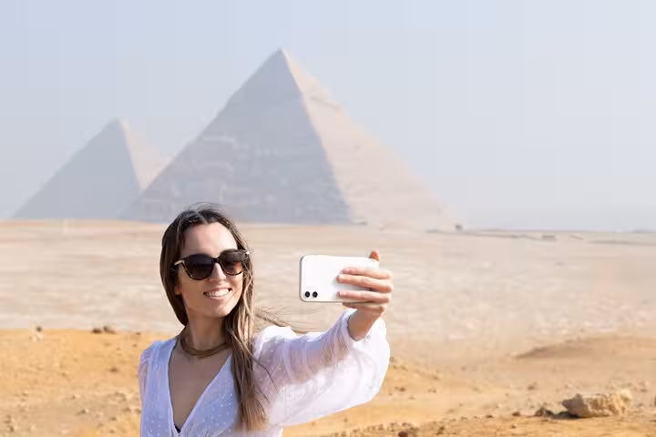 Traveler taking a selfie at the Giza Pyramids on a Cairo full-day private tour with optional camel ride