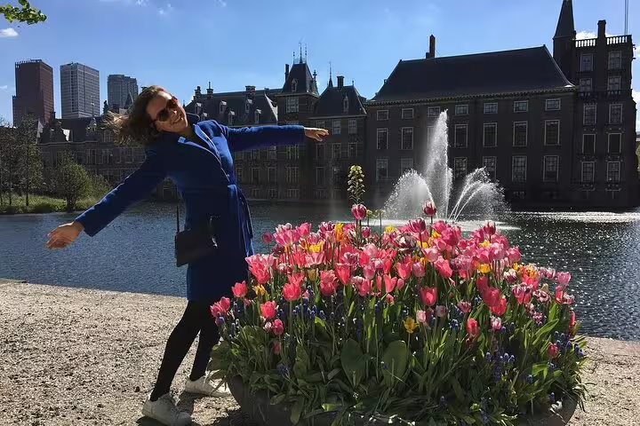 Traveler by tulips at Hofvijver with Binnenhof fountains, Your Own Hague royal city behind-the-scenes tour