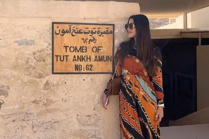 Traveler beside Tomb of Tutankhamun sign in Valley of the Kings on Comfort Luxor tour from Hurghada