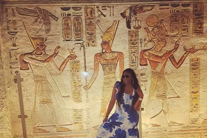 Traveler posing by colorful tomb wall paintings in Valley of the Kings, Luxor 2-day private tour