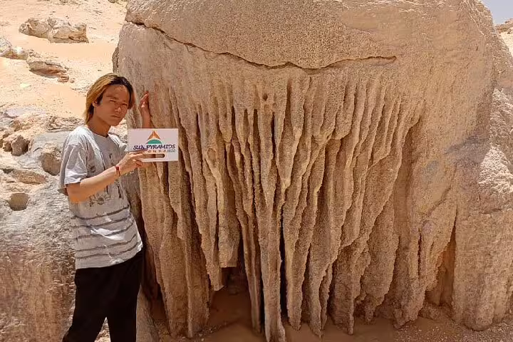 Traveler beside giant chalk formation in White Desert, Egypt, on a private 4-day Bahariya Oasis safari tour