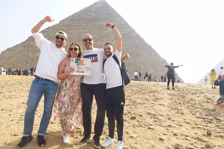 Happy travelers posing at the Great Pyramid of Giza during a 4-day private Cairo tour, guided sightseeing photo