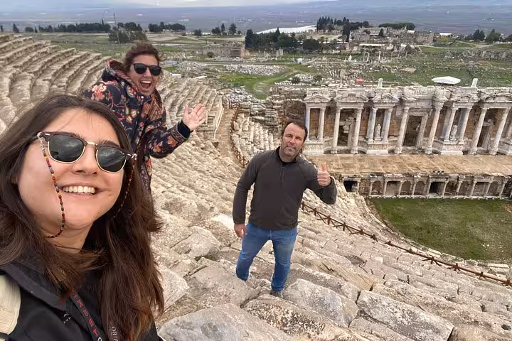 Travelers posing in Hierapolis amphitheater on private Pamukkale day tour from Kusadasi or Selcuk
