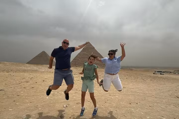 Travelers jumping in the desert with Giza Pyramids backdrop during 3-day Cairo and Giza private sightseeing tour