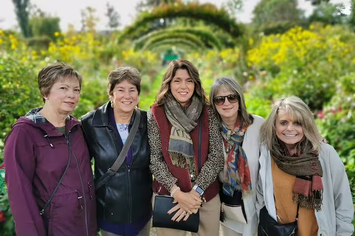 Small group of travelers posing in Monet’s Garden, Giverny, on a private Paris to Rouen day tour