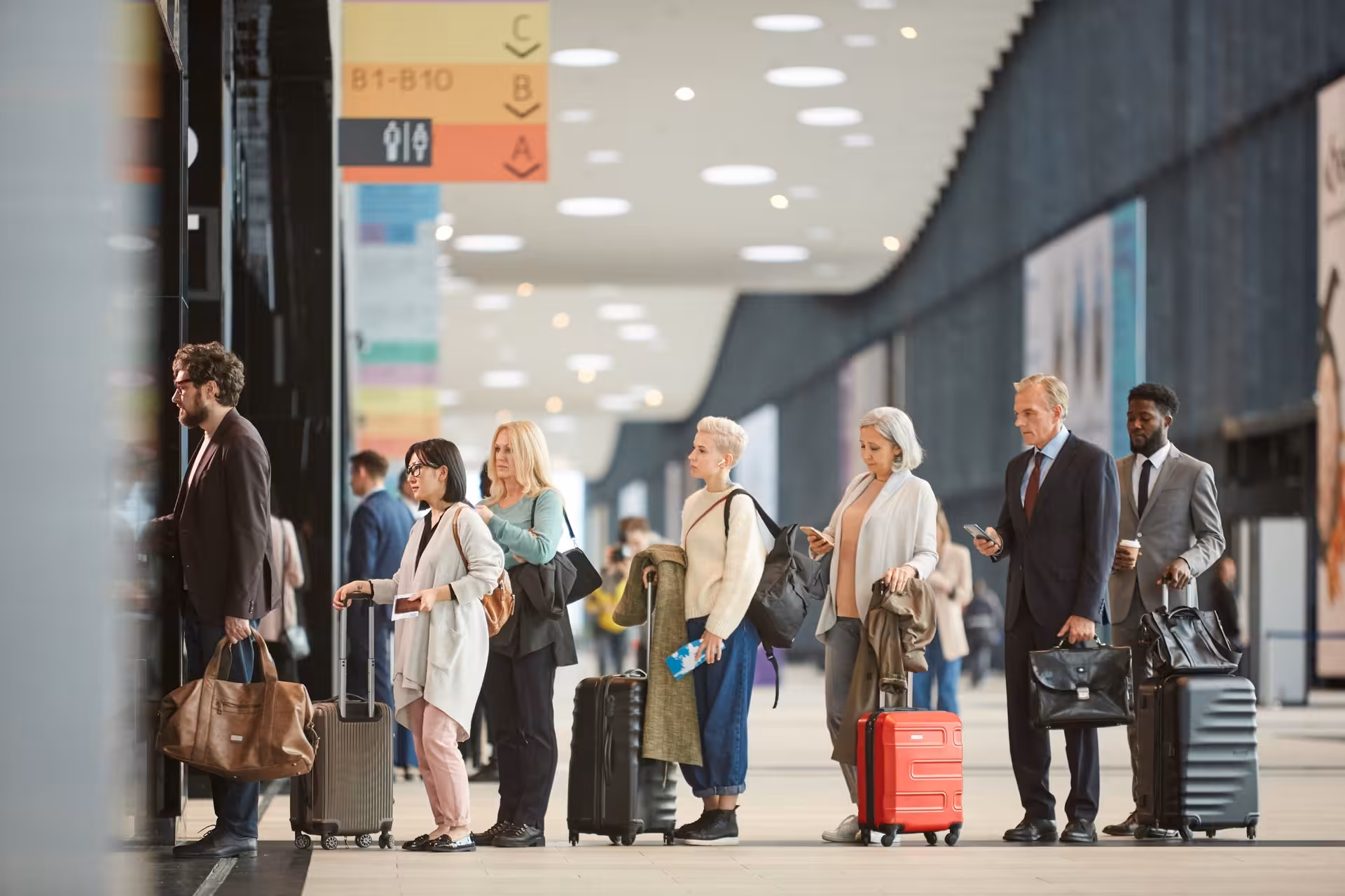 Travelers with luggage queuing at Keflavik Airport terminal before transfer to Reykjavik