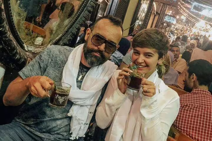 Travelers sipping tea in a lively bazaar cafe, showcasing local culture on the citadel and bazaars tour