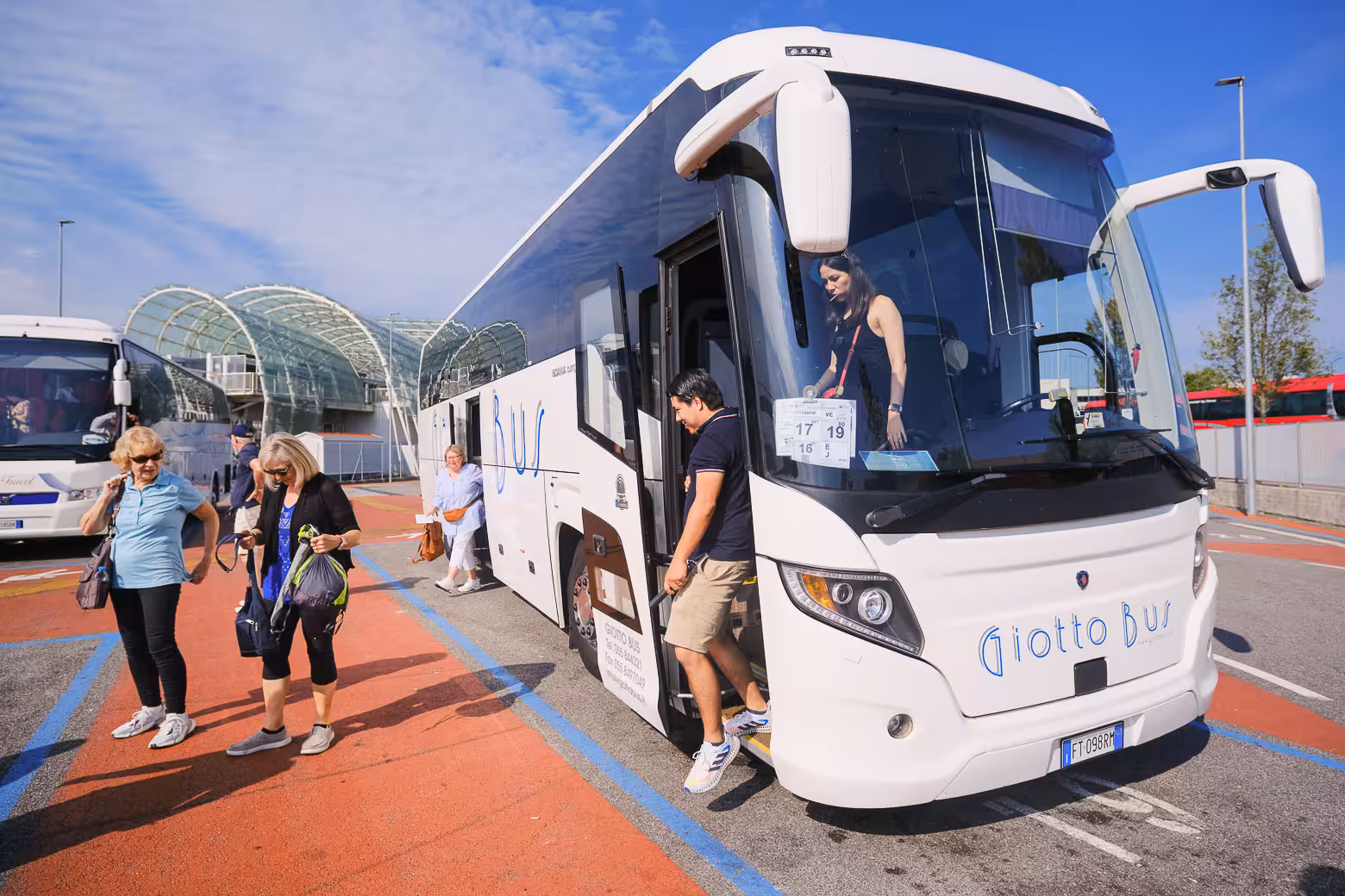 Travelers disembarking from a tour bus in Venice, ready for a scenic adventure to the floating city.