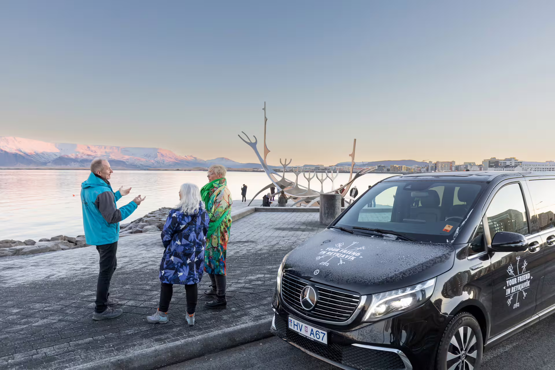 A group of travellers listening to a story by the Sun Voyager in Reykjavik.
