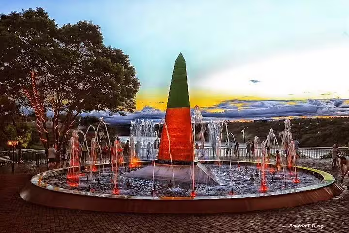 Illuminated Tres Fronteiras Landmark at dusk with vibrant fountains, ideal for a scenic guided tour visit.