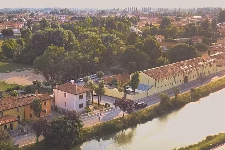 Aerial view of a scenic route from Treviso Airport to Venice, showcasing lush greenery and charming Italian architecture.