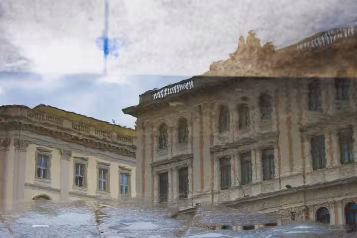 Reflection of ornate Trieste palazzo in a rain puddle, captured on a photography-focused private walking tour with local guide