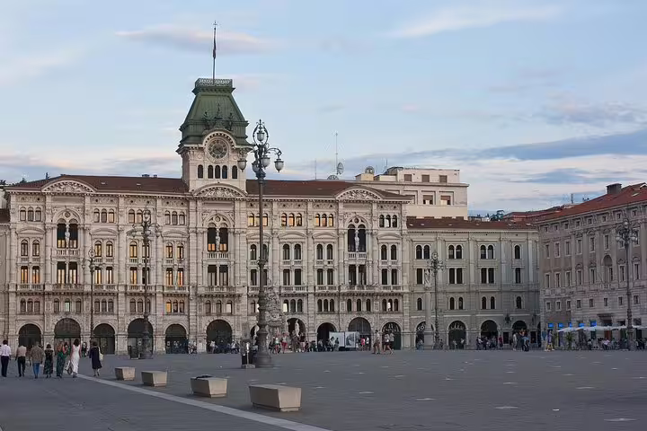 Piazza Unità d’Italia in Trieste at dusk, showcasing ornate palaces and lively square on a private walking tour with guide