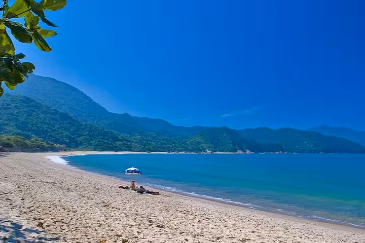 Serene Trinidad beach with turquoise waters and lush mountains, ideal for relaxation and nature exploration.