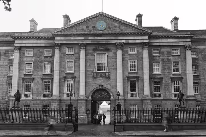 Trinity College Dublin neoclassical facade with iron gates and statues in black and white