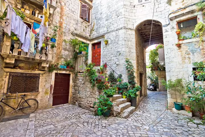 Charming cobblestone alley with plants in Trogir old town, visited on the Blue Lagoon & 3 Islands speedboat tour