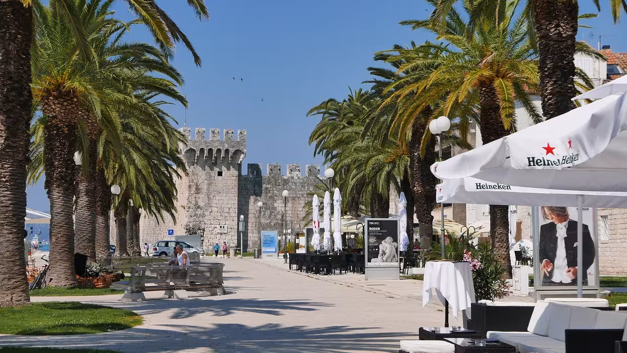 Palm-lined promenade by Trogir Old Town walls, Croatia, scenic stop on the Discover Trogir & Klis Fortress tour