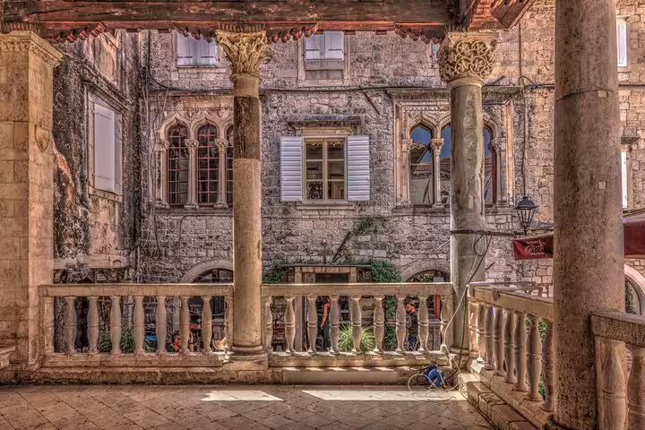 Historic stone courtyard with columns in Trogir Old Town, scenic stop on a private guided walking tour