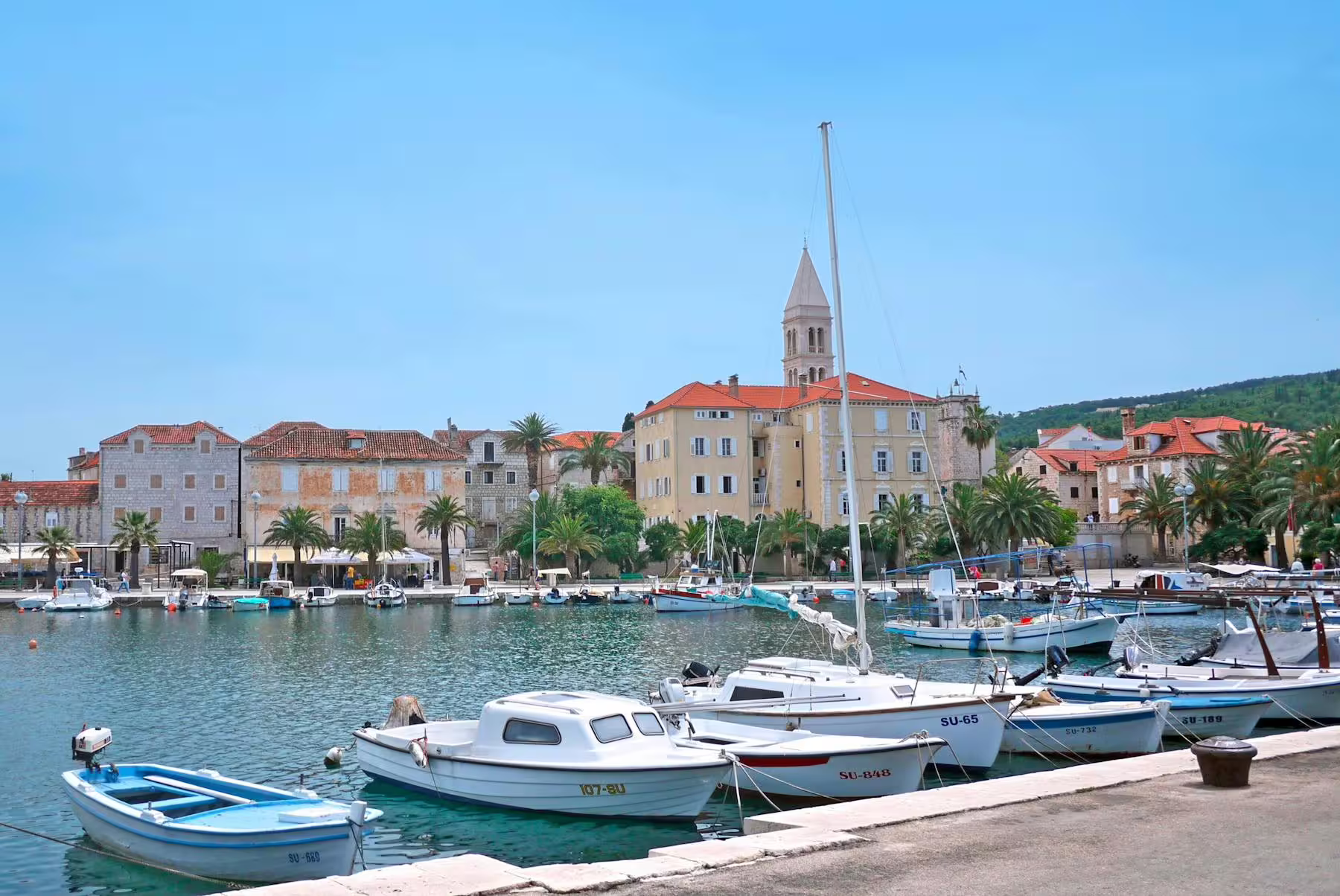 Trogir waterfront marina with boats and church tower, scenic stop on day trip from Makarska Riviera to Split