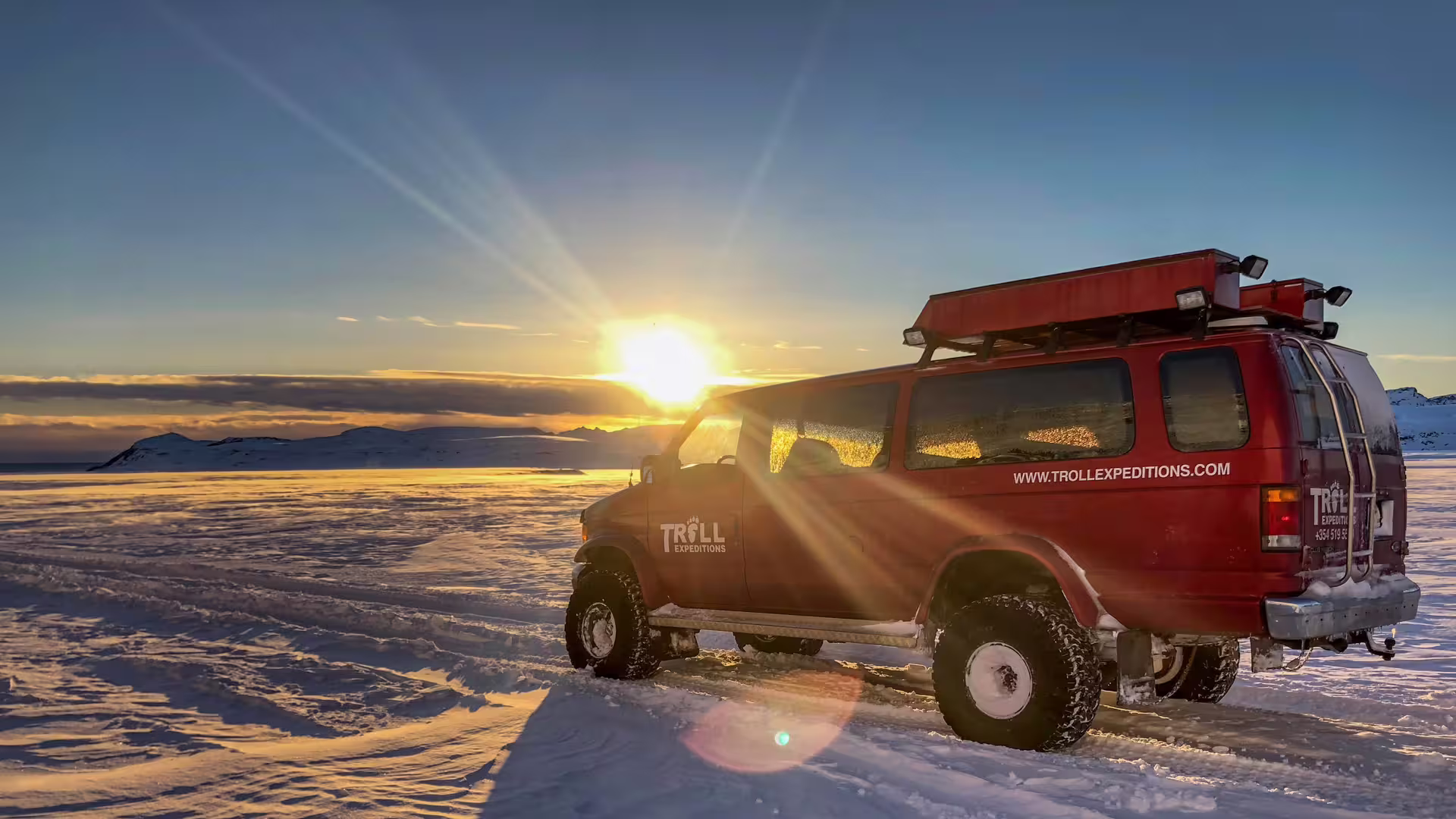 Red Troll Expeditions 4x4 super jeep on Vatnajokull glacier snowfield at golden sunset