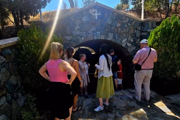 Group visiting a stone chapel entrance in the Troodos Mountains, part of Kykkos Monastery day tour from Paphos