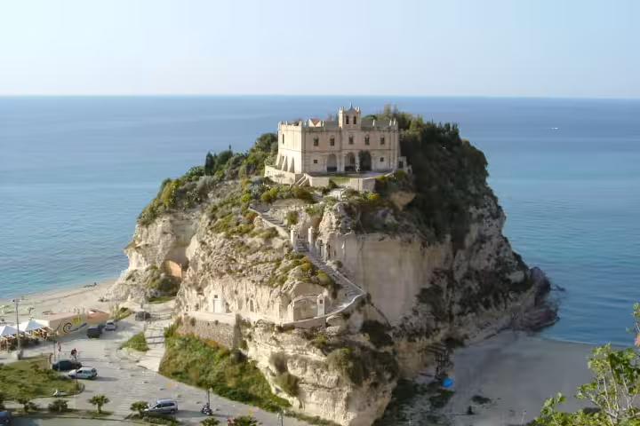 Panoramic view of Tropea’s Sanctuary of Santa Maria dell’Isola perched on a cliff above turquoise Tyrrhenian Sea beaches