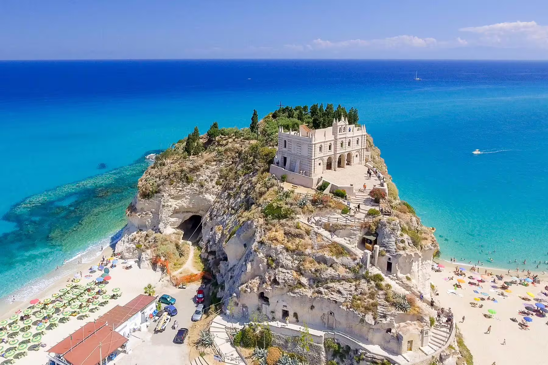 Panoramic view of Tropea’s Santa Maria dell’Isola monastery perched on a cliff above turquoise Tyrrhenian Sea beaches in Calabria