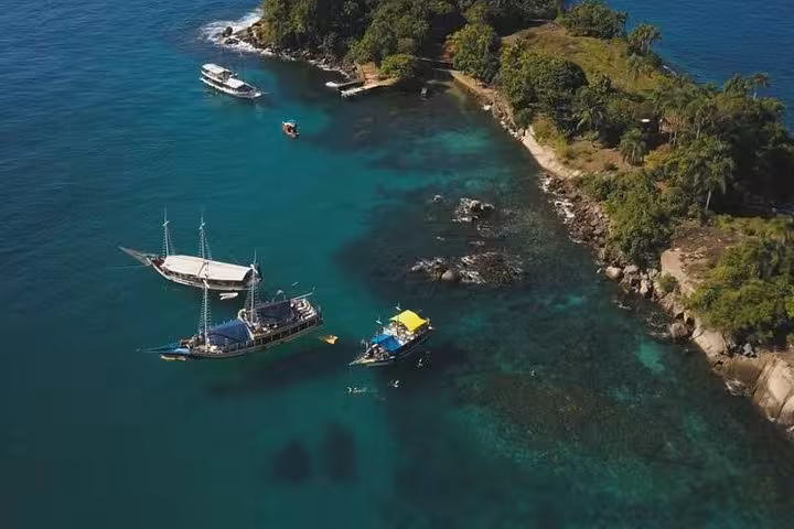 Aerial view of tropical coastline with anchored boats, perfect for an adventurous boat tour experience.