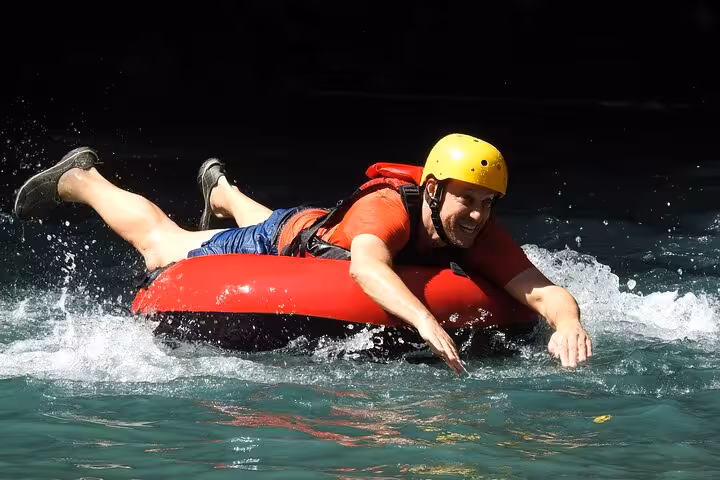 Smiling participant tubing down the Celeste River, experiencing exciting water adventure in Costa Rica.