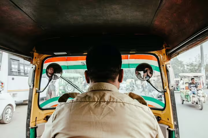 View from inside a tuk tuk behind the driver, showing street traffic on an authentic Egypt tuk tuk tour