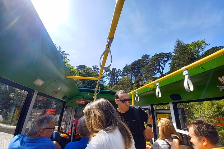 Guests riding an open-air tuk tuk through Sintra forest on a guided Sintra Cascais palaces tour