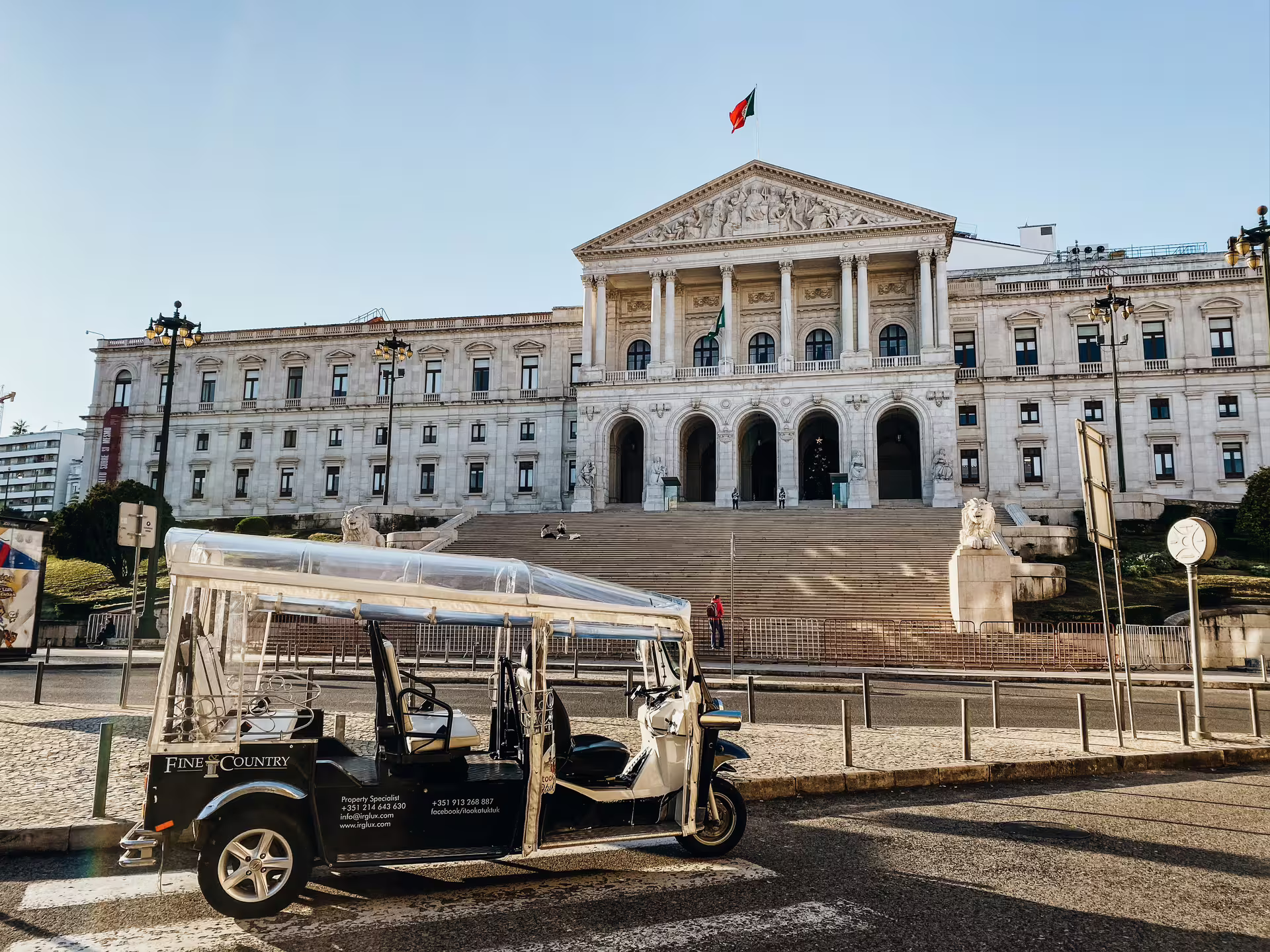 Tuktuk in front of Lisbon's grand historical building, offering a glimpse into the city's rich heritage.