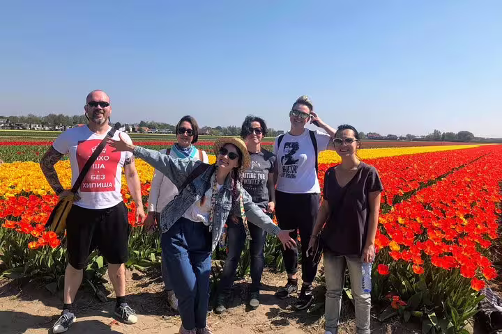 Small group photo in vibrant tulip fields during Your Own Holland tulip tour by electric bike in the Netherlands