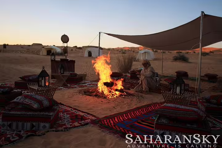 Traditional campfire setting in the Tunisia Sahara desert with rugs and lanterns, perfect for a cozy evening adventure.