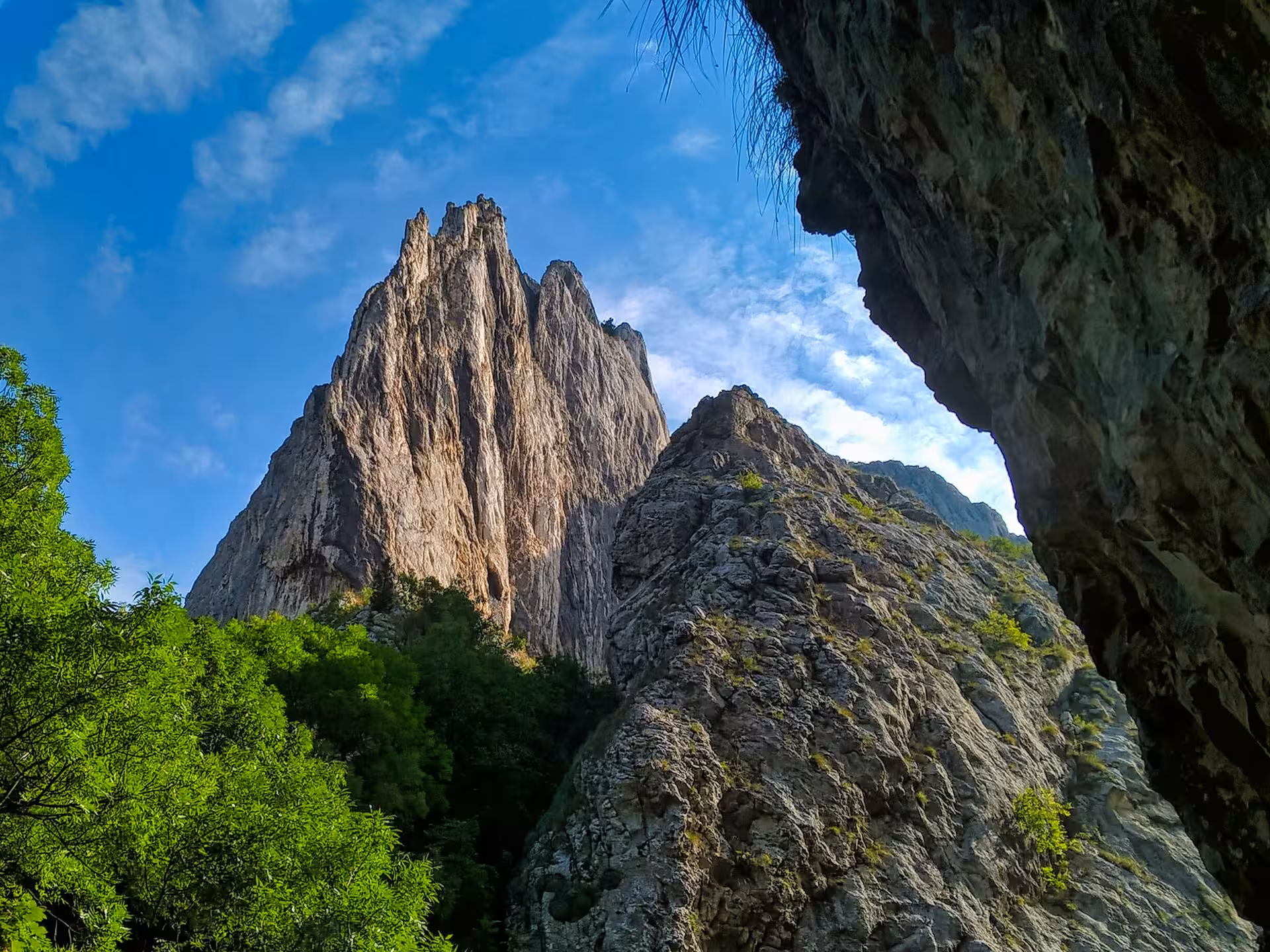 Dramatic limestone rock formations of Turda Gorge towering under blue sky on a scenic day trip from Cluj