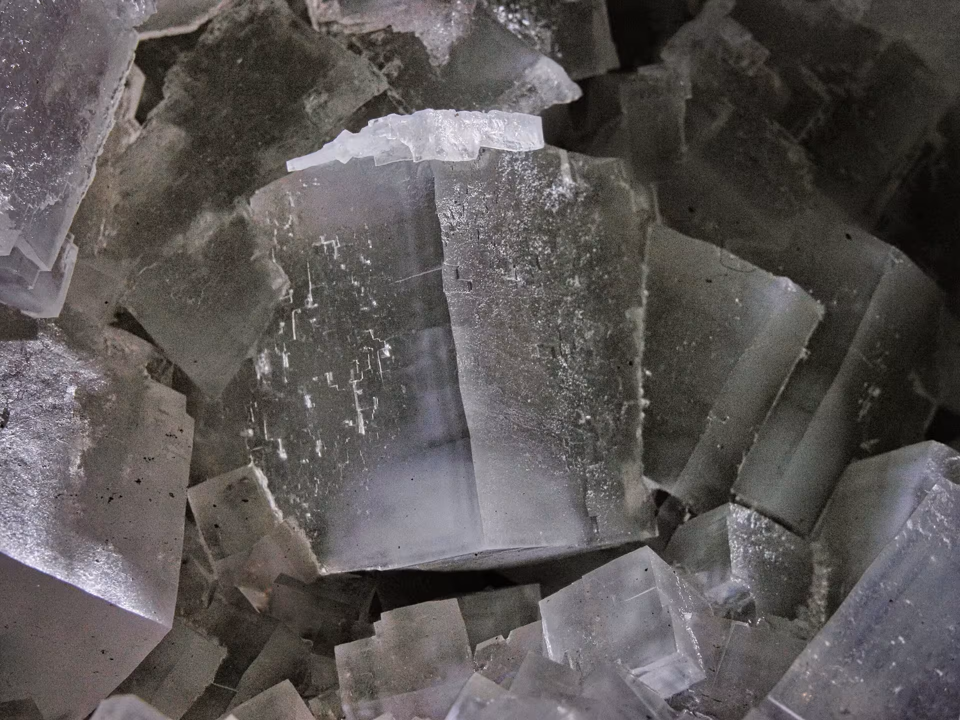 Large grey salt crystal formations inside Turda Salt Mine, showing cubic cleavage surfaces