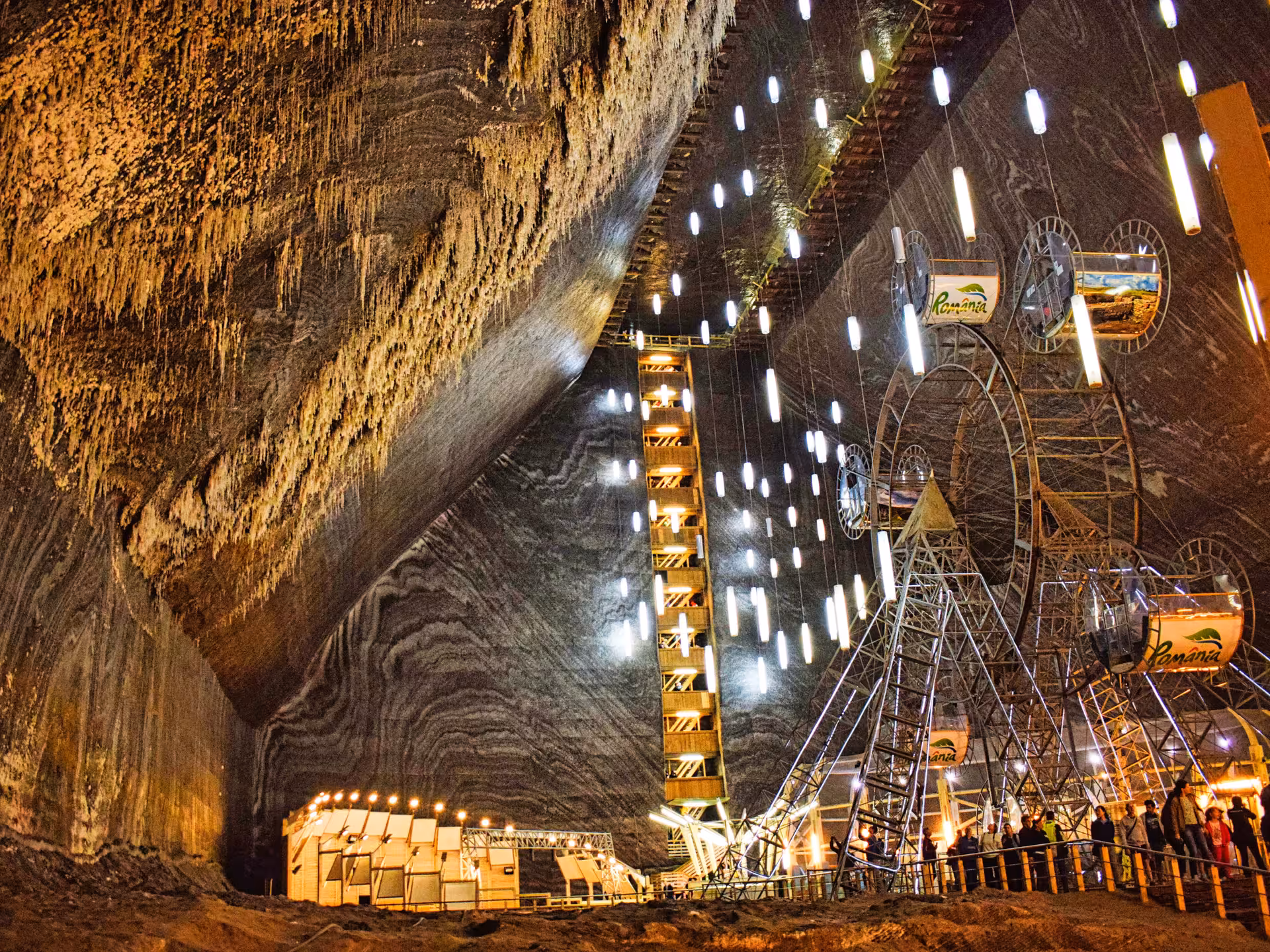 Stunning interior of Turda Salt Mine featuring a Ferris wheel and glowing lights inside massive salt caverns Romania