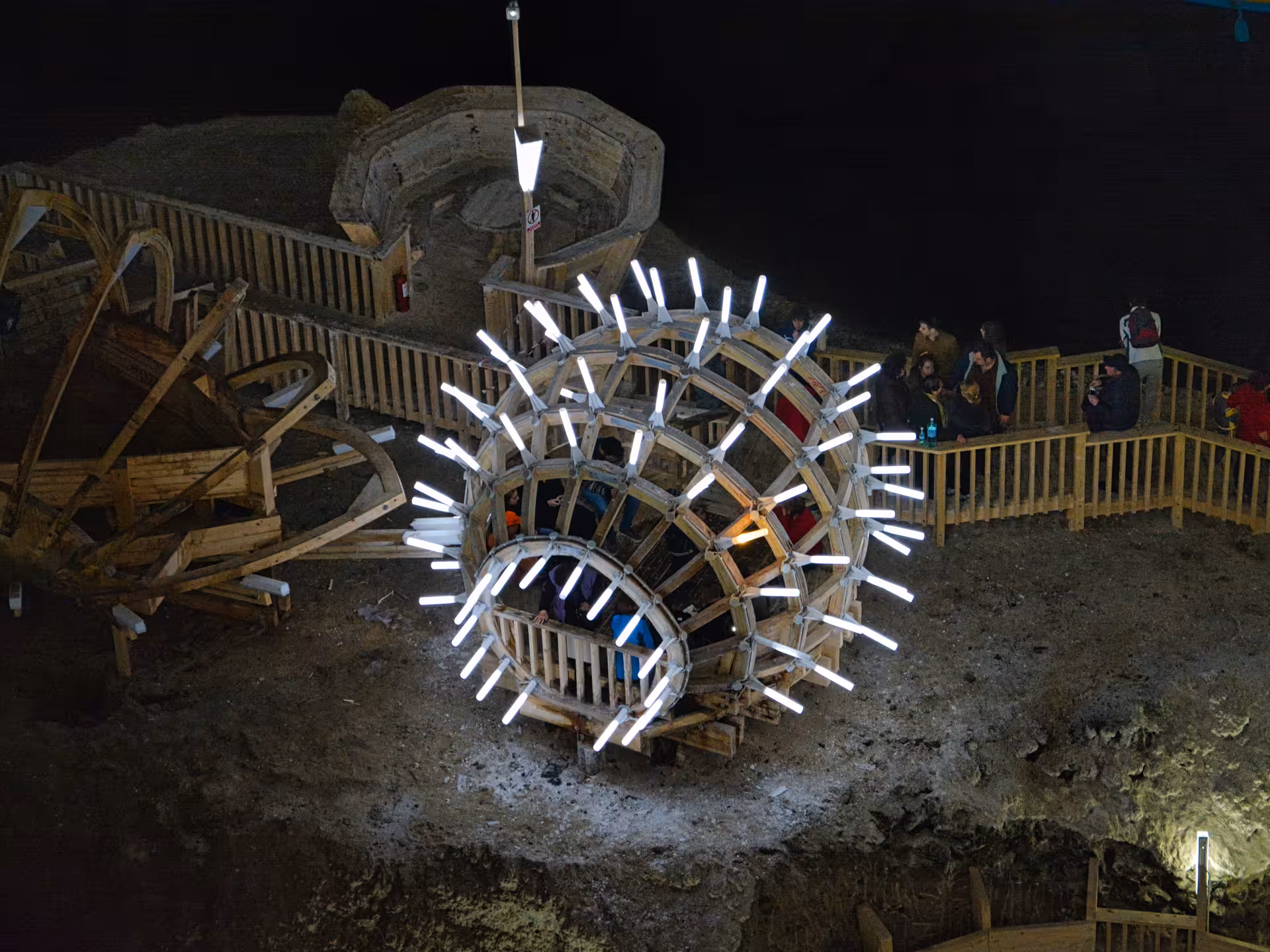 Illuminated wooden ferris wheel installation inside Turda Salt Mine Romania on a full-day tour from Cluj