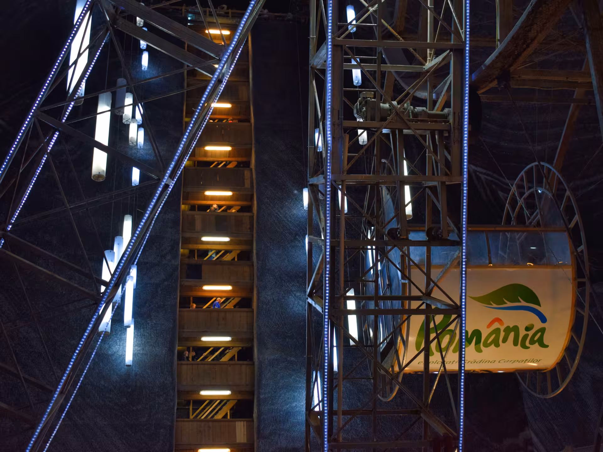 Illuminated Ferris wheel and multi-level wooden platforms inside Turda Salt Mine, Romania