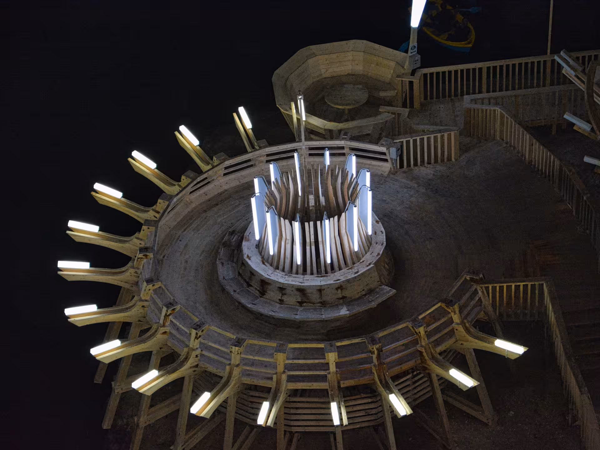 Stunning upward view of the illuminated wooden circular structure inside Turda Salt Mine on a Romania day tour