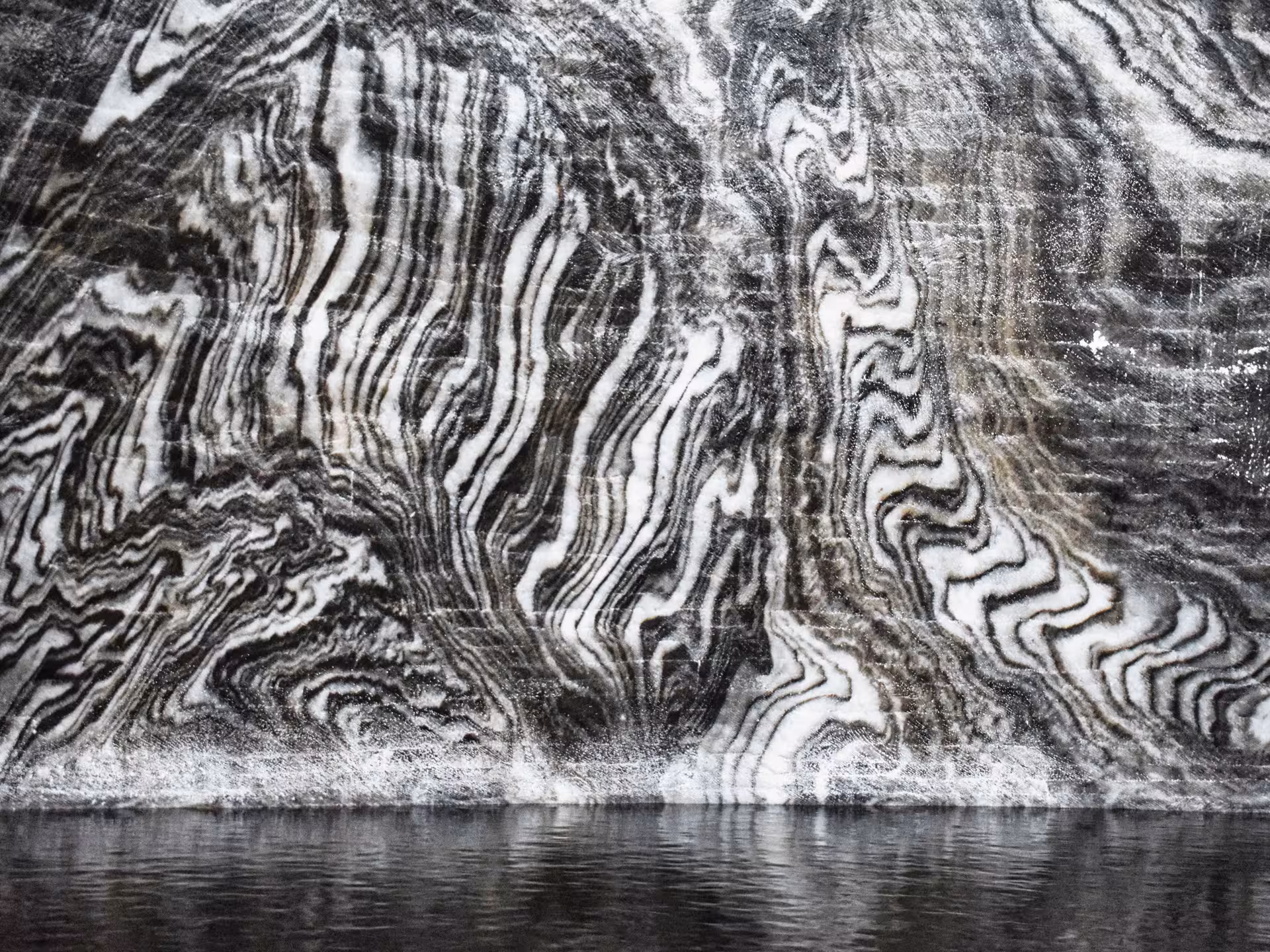 Striking swirling salt rock layers with underground lake reflection at Turda Salt Mine day trip from Cluj