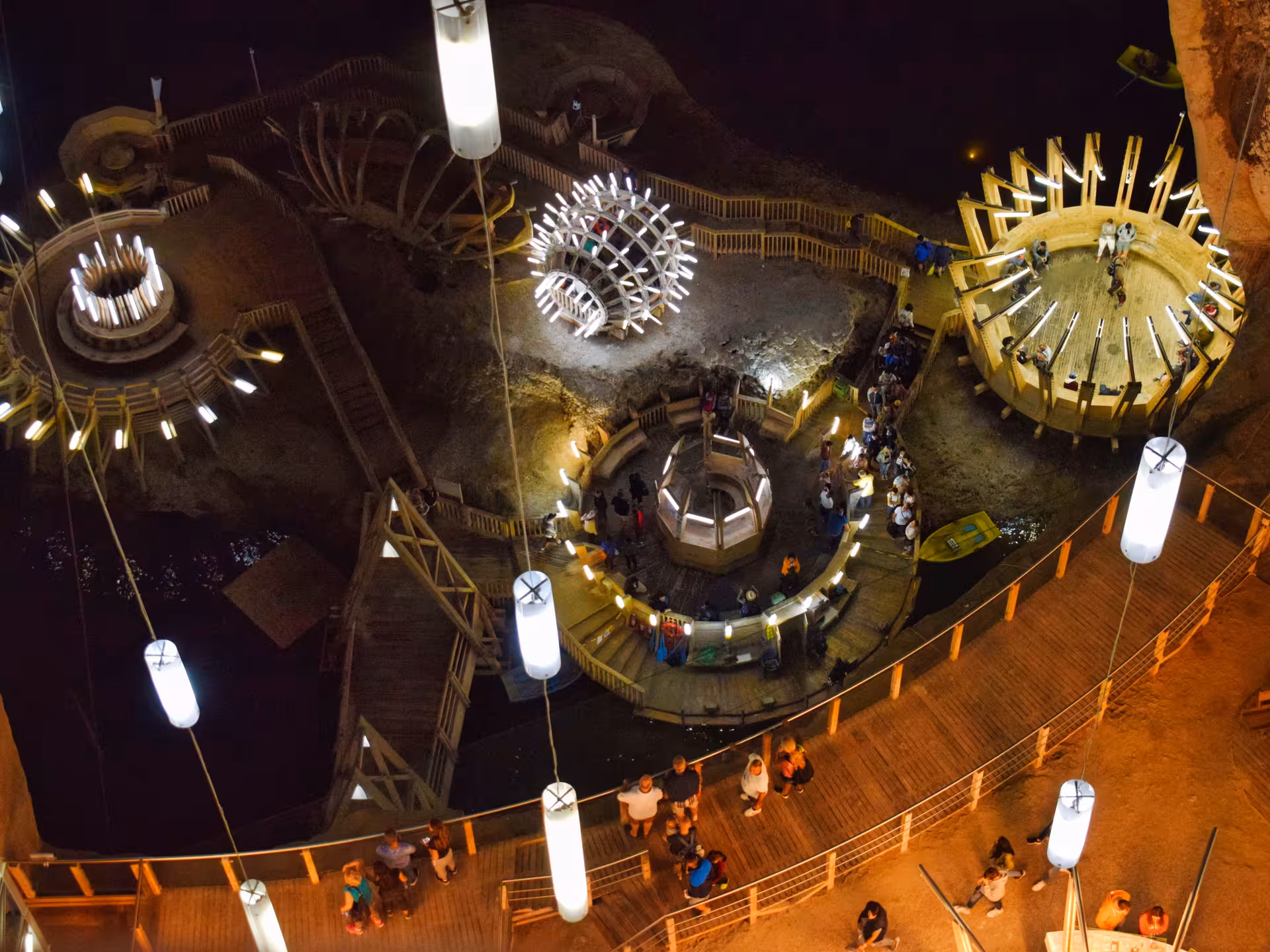 Aerial view of Turda Salt Mine's stunning underground chamber with wooden structures and glowing lights