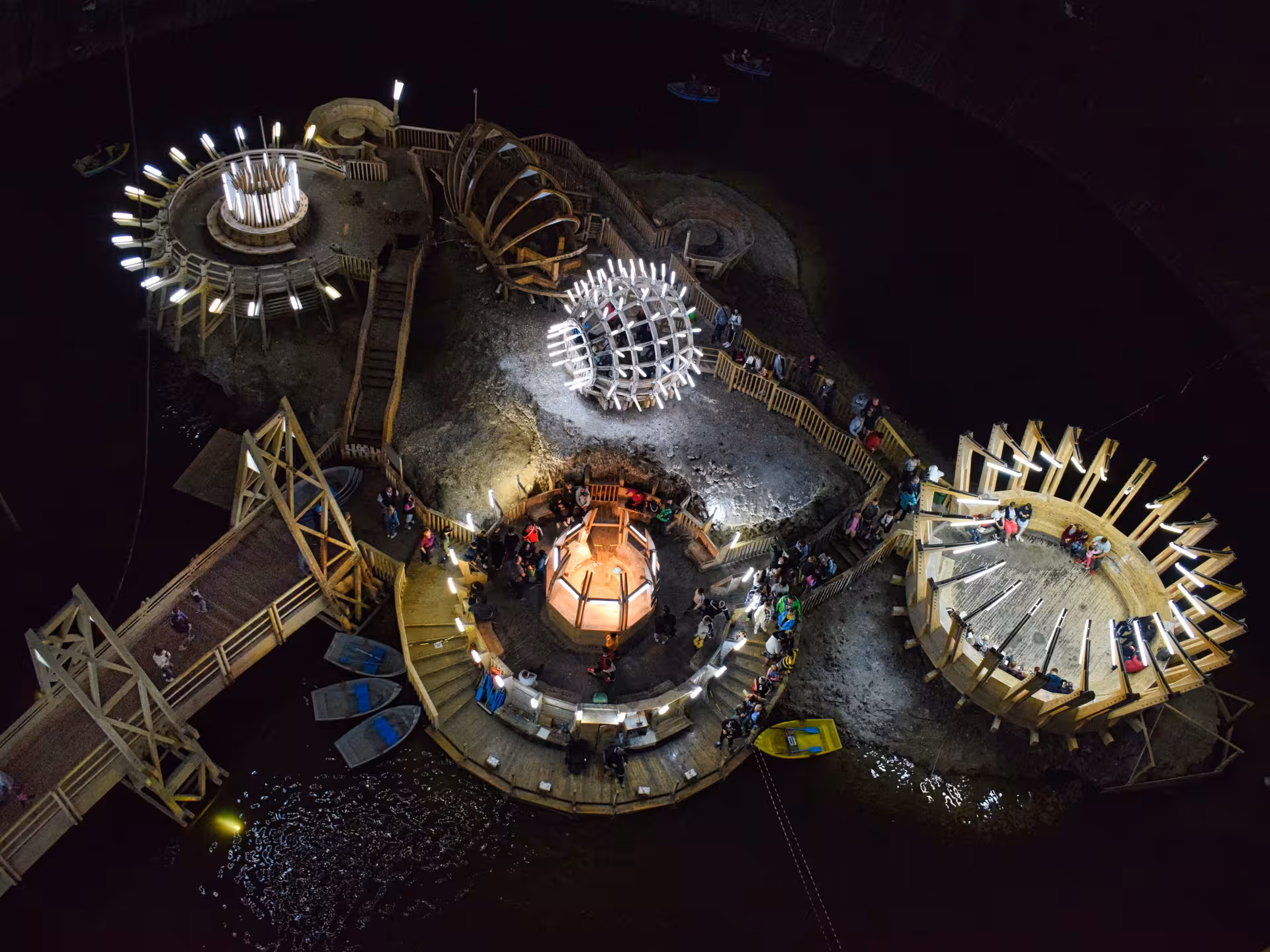 Aerial view of Turda Salt Mine underground island with wooden structures lights and rowing boats from Cluj day trip