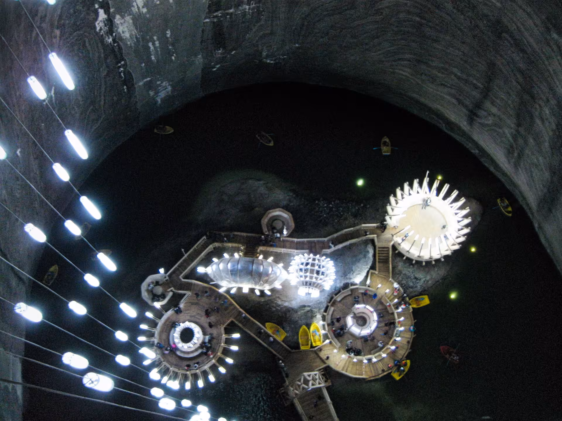 Aerial view of Turda Salt Mine underground amusement park with circular platforms and underground lake in Romania