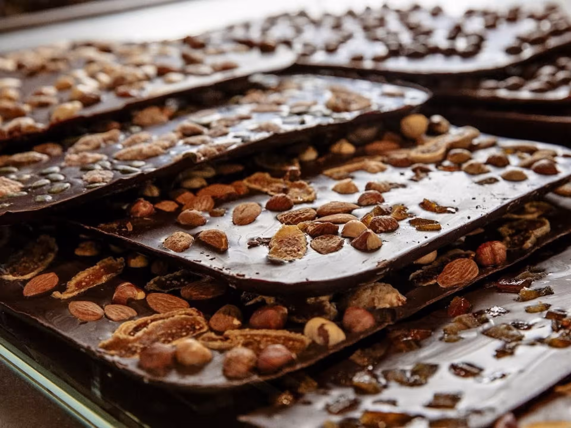 Artisan chocolate slabs topped with assorted nuts and dried fruits at Turin Chocolate Factory tour and tasting.