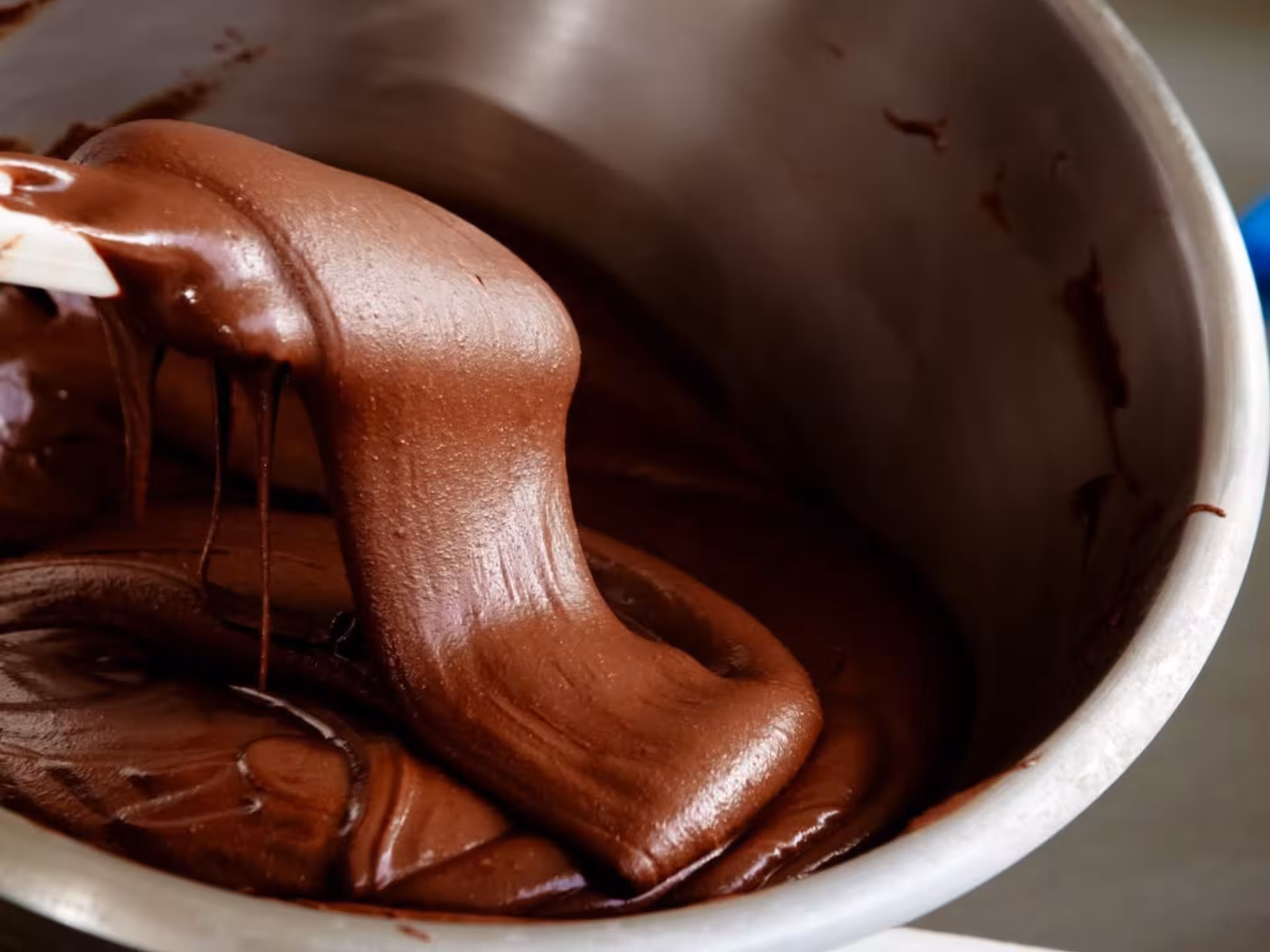Luxurious melted chocolate swirls in a mixing bowl during the Turin Chocolate Factory tour and tasting experience.