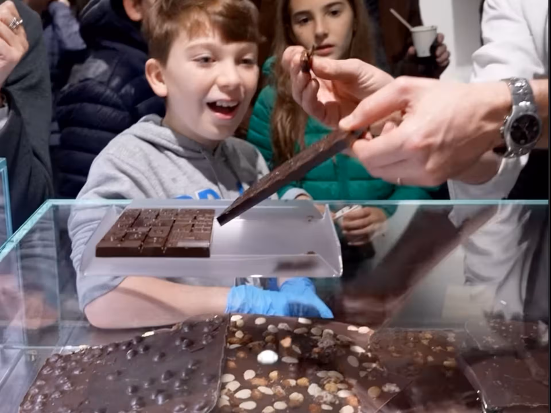 Excited visitors sampling chocolate during the Turin Chocolate Factory guided tasting tour.