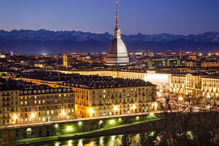 Night view of Turin skyline with Mole Antonelliana and Alps, highlight of a personalized top sights walking tour