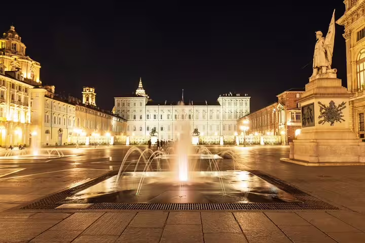 Piazza Castello Turin illuminated at night with fountain and Royal Palace in background