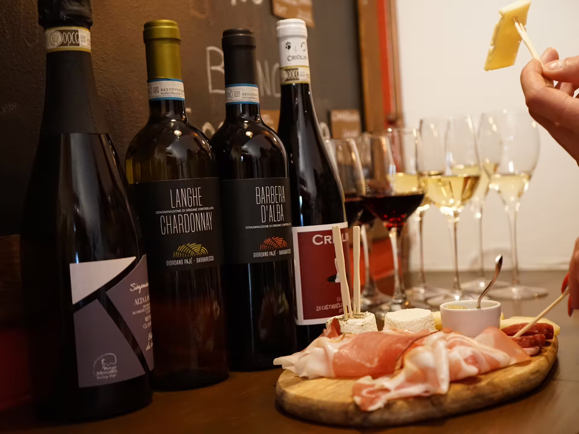 Turin city center wine tasting with Barbera d’Alba and Langhe Chardonnay bottles, glasses, and aperitivo board